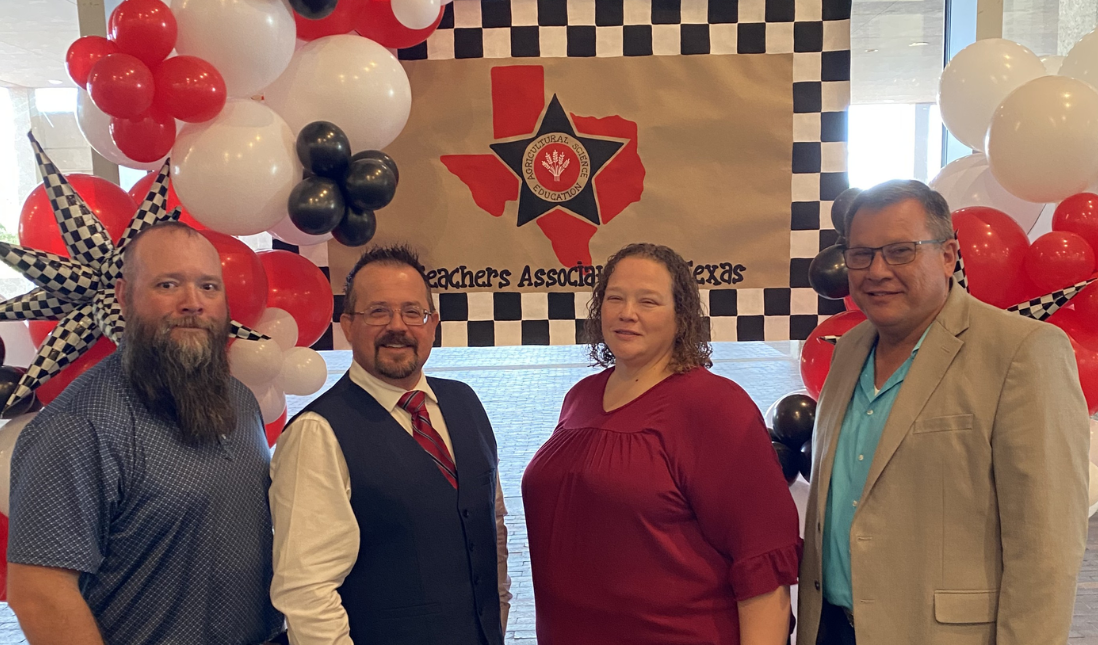 The four Navarro HS Agriculture Science teachers are standing in front of a balloon backdrop at the Ag Teachers Association of Texas Professional Development Conference.